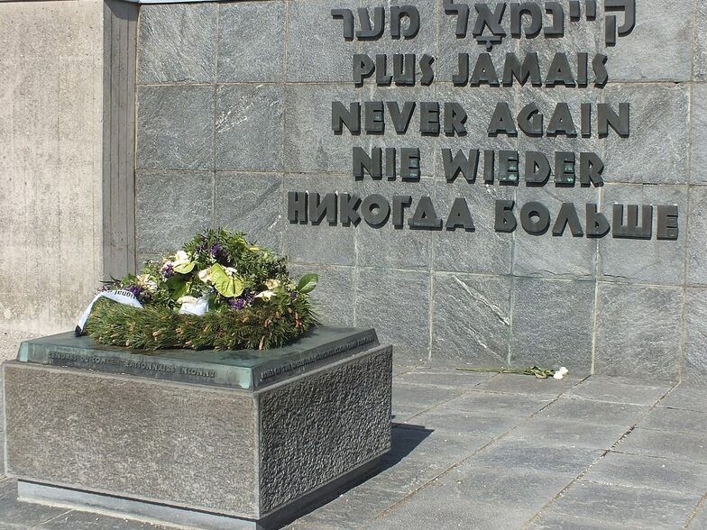 Memorial on the grounds of the former Dachau concentration camp with the words "Never again" in various languages. Public domain.